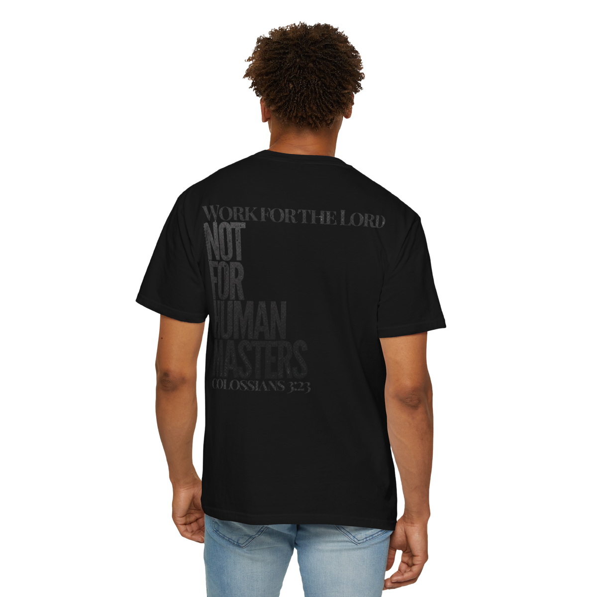 A man viewed from the back wearing a black short-sleeve t-shirt with a dark gray graphic text print on the back reading 'WORK FOR THE LORD NOT FOR HUMAN MATTERS COLOSSIANS 2:3'.
